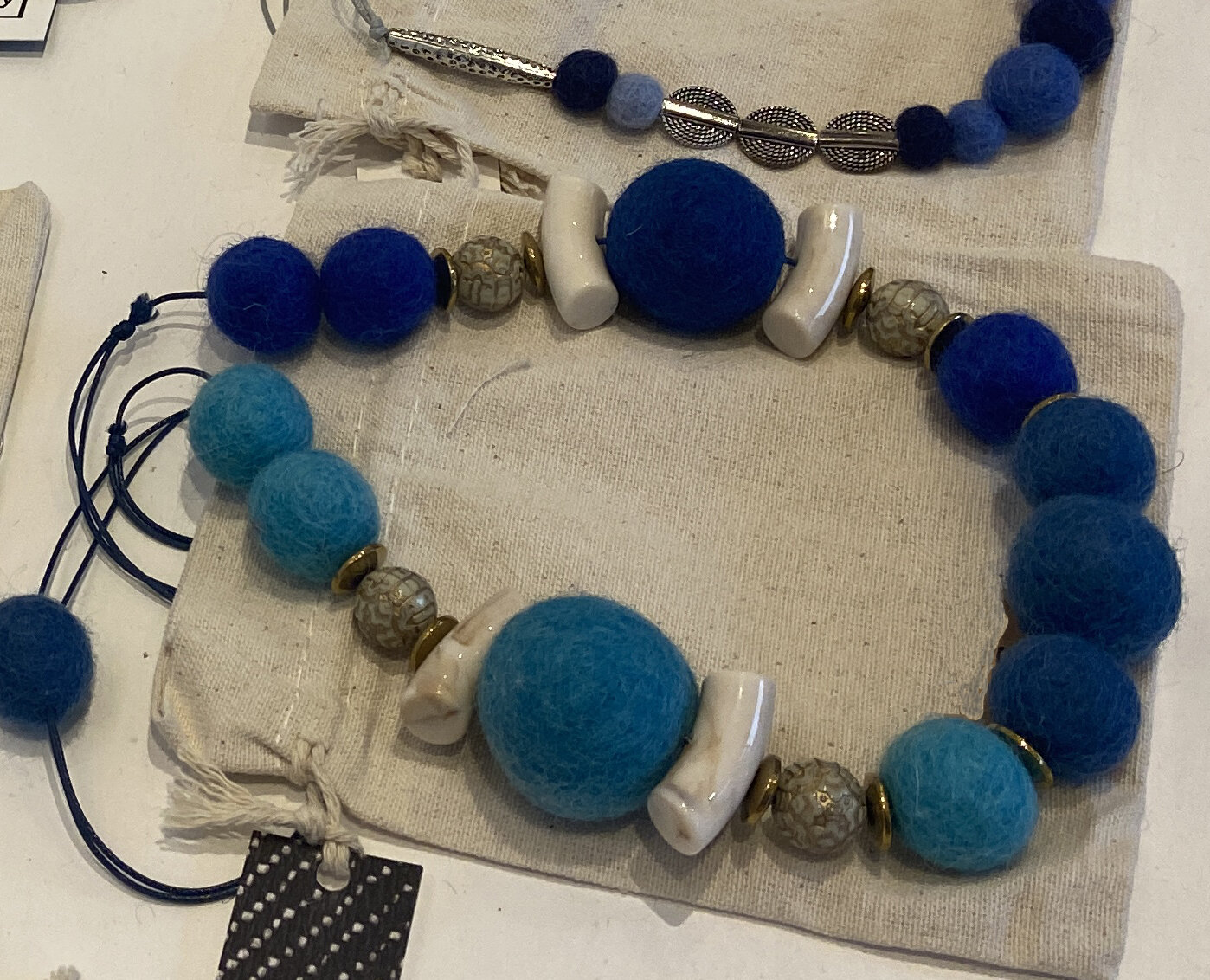Wool, hematite and ceramic necklaces with drawstring purses